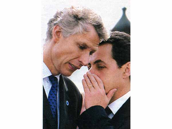 Nicolas Sarkozy whispering to the Minister of the Interior
